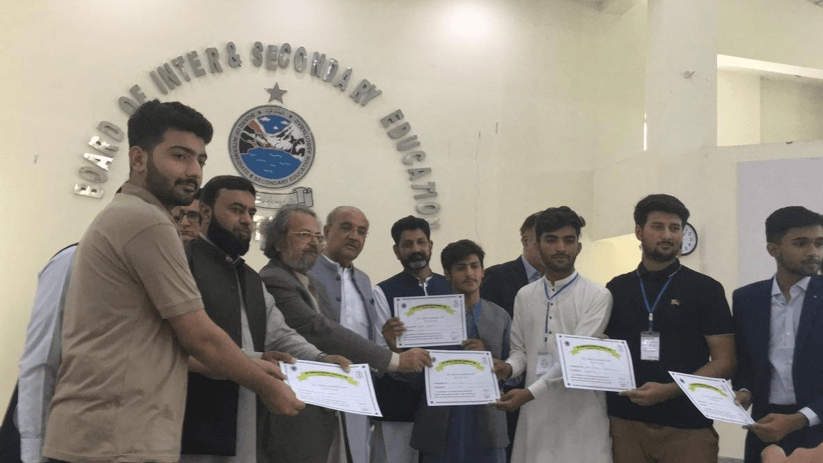 Moeen Ahmad and fellow recipients holding leadership certificates with education officials